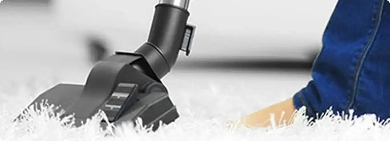 Close-up of a professional vacuuming a white carpet in Rossville.